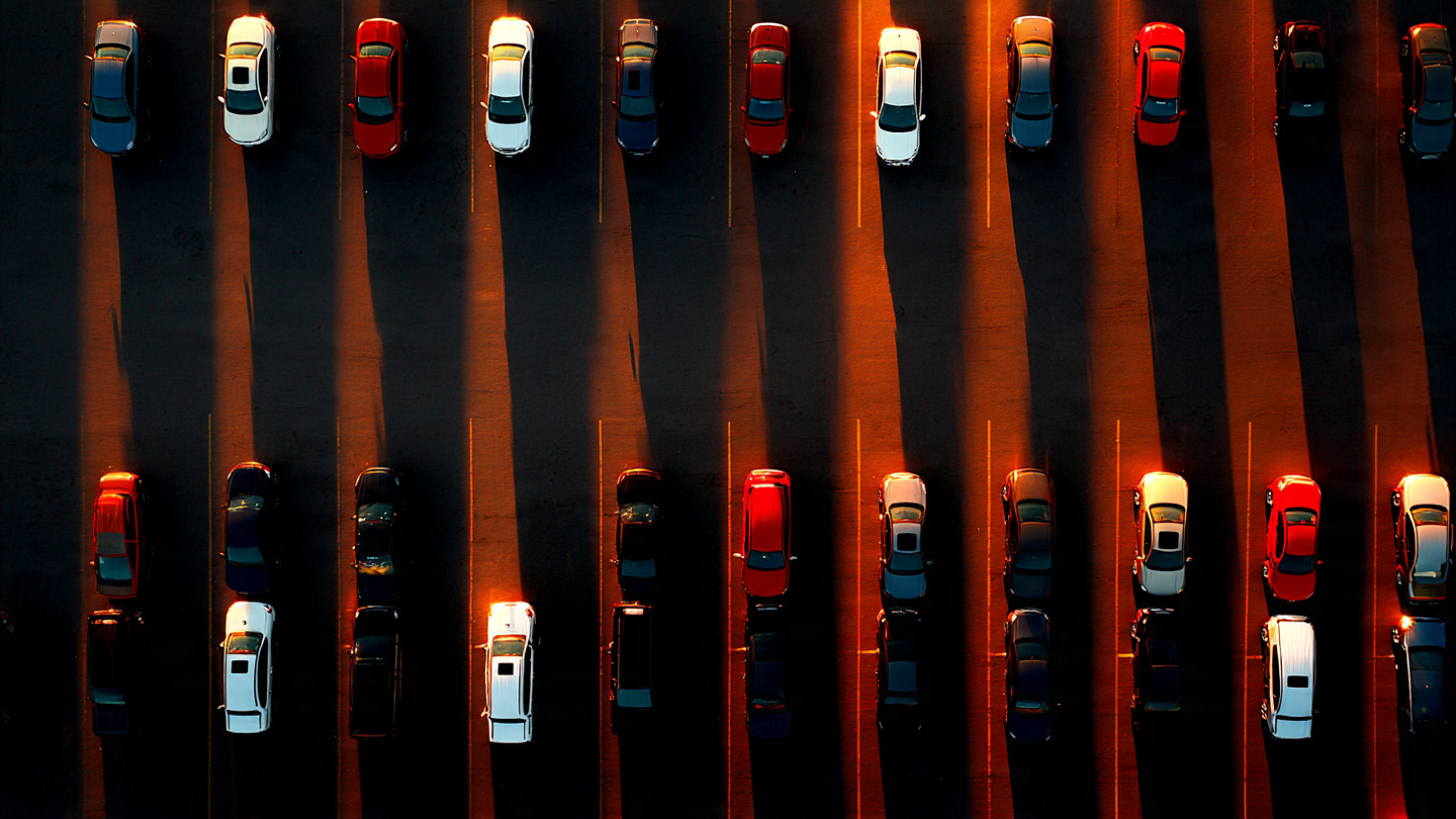 Rows of compact SUVs at a dealership with dramatic lighting