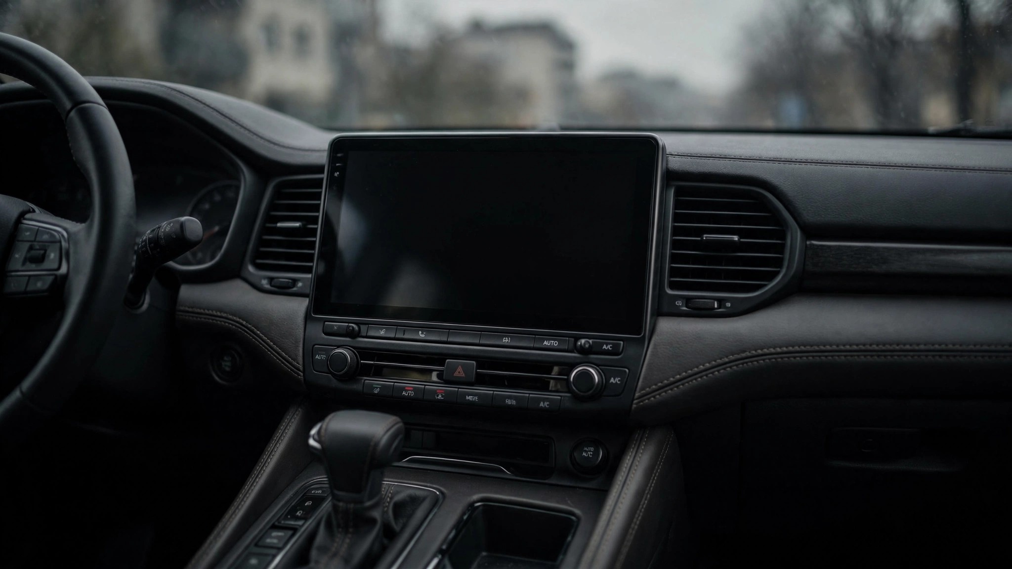 Car dashboard with a large central touchscreen display gone completely black, the blanked-out rearview camera display at the center of the recall